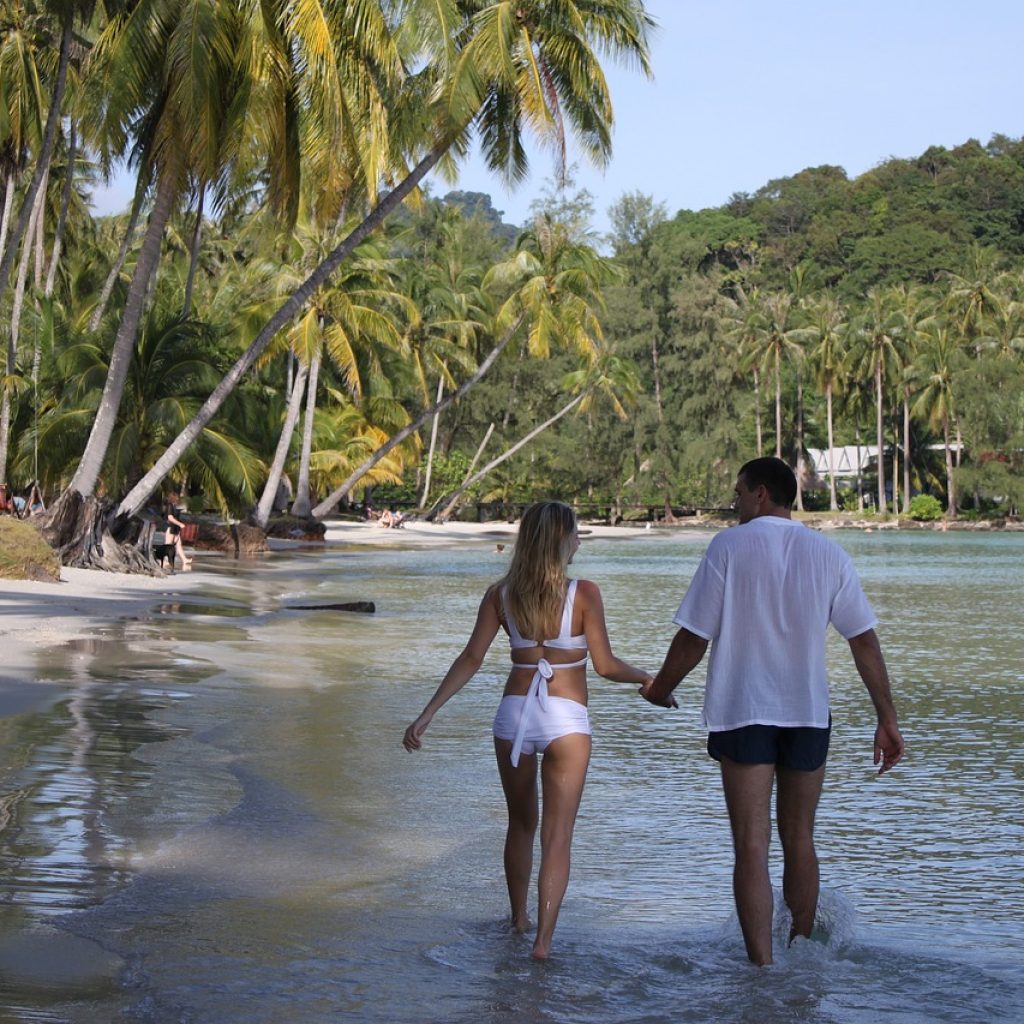 Couple walking hand in hand on a tropical beach in Sri Lanka